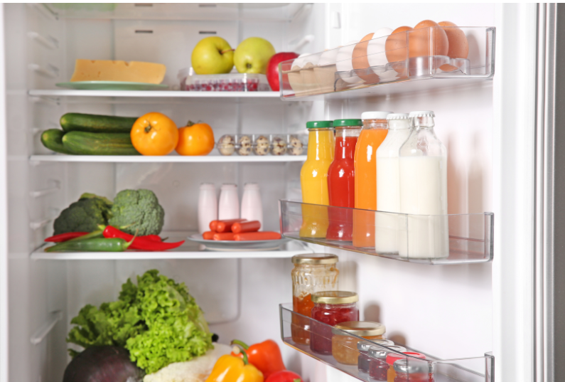 Fridge with nutritious food including eggs, apples, broccoli, peppers, cheese, kale, milk, fresh juices